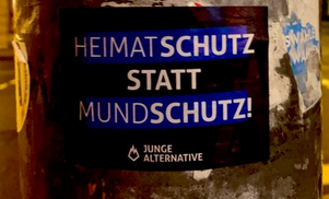 Aufkleber der Jungen Alternative mit der Aufschrift "Heimatschutz statt Mundschutz", "Schutz" ist jeweils fett markiert.