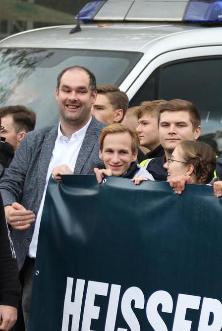 Carolin Lichtenheld, Patrick Fleischer und Stefan Schröder tragen ein Transparent der Jungen Alternative lachend auf einem Aufmarsch