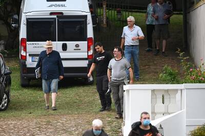 Mehrere Personen laufen am 27.8.2022 beim rechtsextremen Sommerfest des Compact-Magazins in Stößen über einen Parkplatz. In der Mitte läuft Lars Kühne in einem T-Shirt von "Compact" mit der Aufschrift "Wir sind frei".
