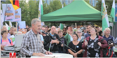 Bild von der rechten Kundgebung am 5.9.2022 in Leipzig: Während der Zeulenrodaer Reichsbürger und Antisemit Frank Haußner eine Rede hält, sieht man Lars Kühne aus der zweiten Reihe zuhören. Im Hintergrund ist ein Stand der Neonazi-Splitterpartei "Freie Sachsen" zu sehen.