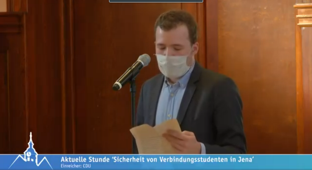 Foto von Benedikt Kern-Wagner vorm Mikro mit Text in der Hand