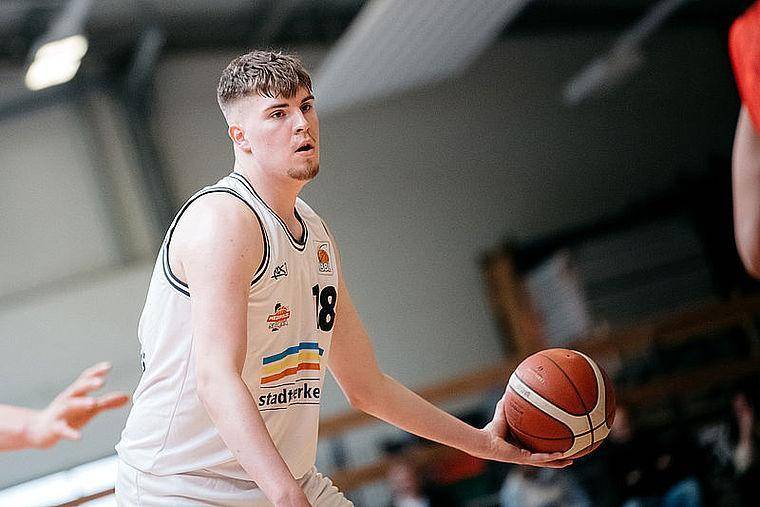 Johann Walter ist bei einem Spiel von Science City Jena mit dem Basketball in der linken Hand in einem weißen Trikot zu sehen.