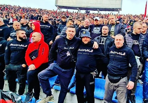 Eine Gruppe von bulgarischen Hooligans der Animals steht in einheitlichen Pullovern im Stadion. Vorne stehen Arm in Arm Michael Hein und Orlin Pavlov.
