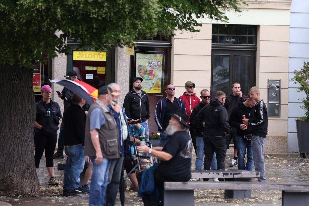 Foto von mehreren Personen, die auf dem Apoldaer Markt bei einer Kundgebung stehen.