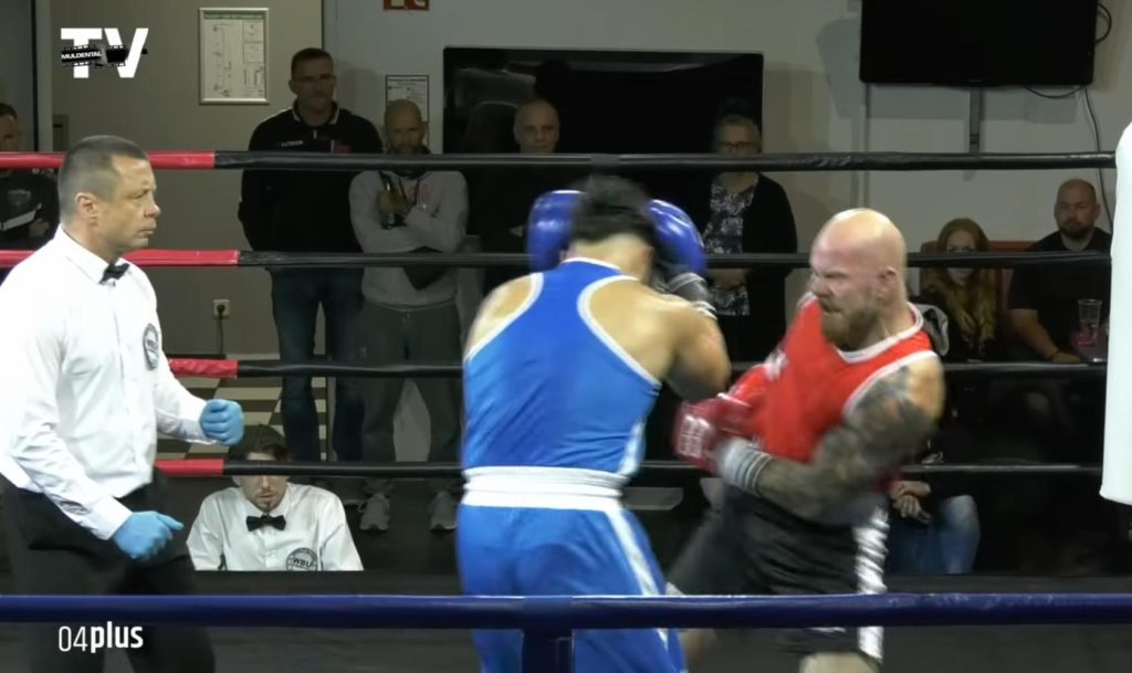 Stefan Rose ist in rotem Tanktop beim Boxschlag gegen einen in blau gekleideten Gegner im Boxring auf einem Screenshot eines Videomitschnitts zu sehen.